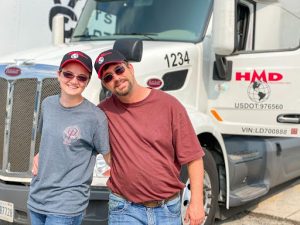 Two mal truckers standing in front of truck